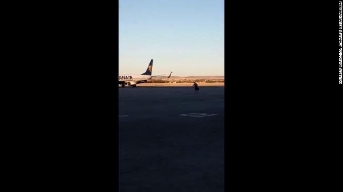 El pasajero esprintó a través de la pista de despeque para intentar y para coger su avión.