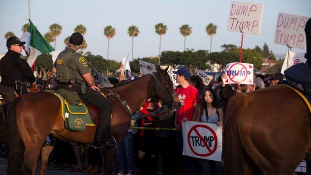 La policía retiene a opositores del triunfo en Costa Mesa, California, el 28 de abril