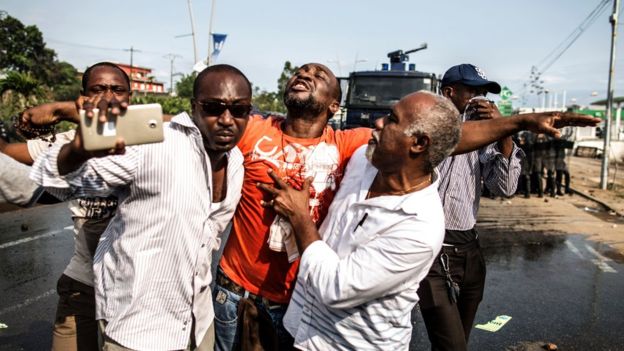 Un partidario del silbido de bala se lleva durante choques con policía